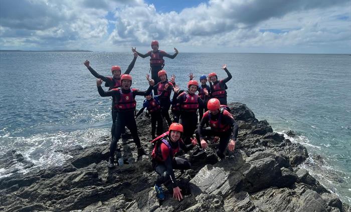 Bearded Men Adventures, People on rocks on the welsh coastline coasteering